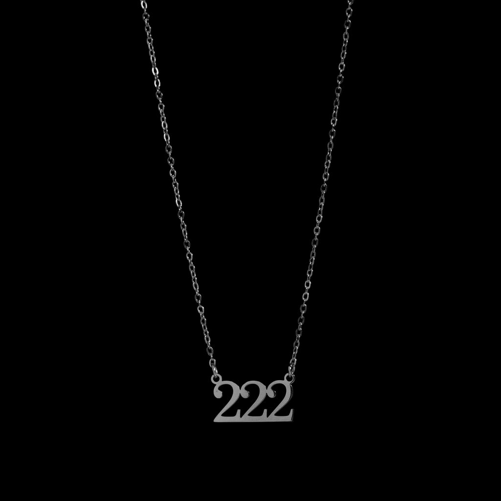 Silver necklace with '222' pendant on a black background